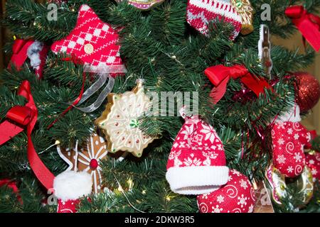 Christmas tree decor close-up with toys in the form of gingerbread and knitted hats. Stock Photo
