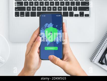 Female hands holding smartphone with vpn app on the screen, top view Stock Photo