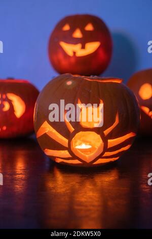 Two lit Jack O Lantern carved pumpkins glowing on Halloween night Stock Photo