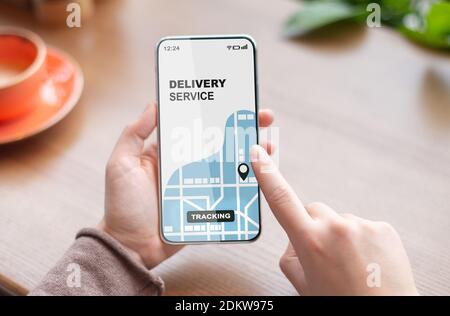 Woman using smartphone with opened delivery service tracking app, checking order status Stock Photo