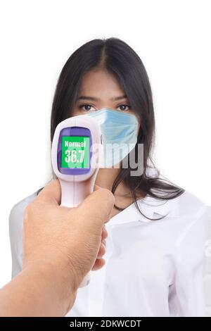 Front view photo of woman who was being measured body temperature with electronic handheld thermometer on white background. Stock Photo