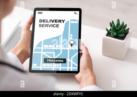 Delivery service tracking app opened on digital tablet in unrecognizable woman's hands Stock Photo