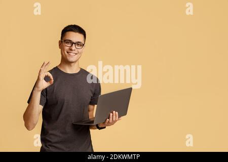 Excellent result, good feedback and vin. Smiling male in glasses expresses emotions of success Stock Photo