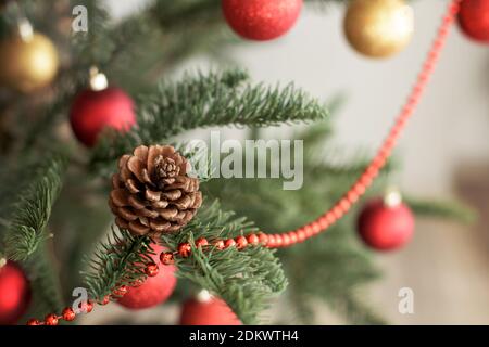 Fir cone on decorated  gold and red Christmas tree Stock Photo