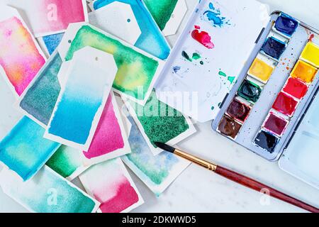 Homemade gift tags made out of watercolor paper and painted with watercolor paint in abstract free flowing designs. Stock Photo