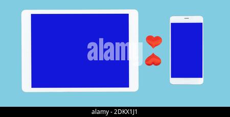 cell phone and tablet computer on blue background. red hearts between gadgets. concept of sending romantic messages. Love chat Stock Photo
