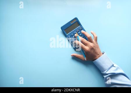 top view of accountant using calculator on blue background  Stock Photo