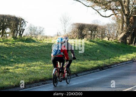 A tandem bicycle ridden on a country road in winter, Warwickshire, England, UK Stock Photo