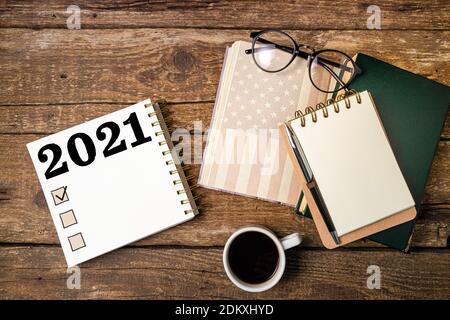 New year resolutions 2021 list. Office desk table with notebooks, coffee cup, american flag. Goal, plan, ideas, business, motivation, checklist concep Stock Photo