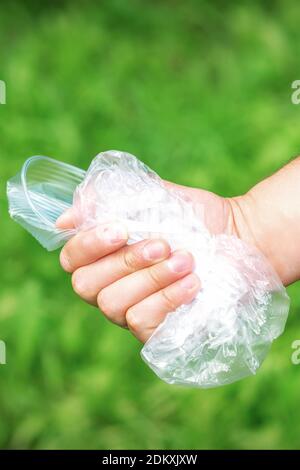 The person holds used crumpled plastic debris in his hand. Environmental problem concept. Stock Photo