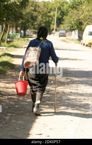 Vrancea County, Romania. Elderly woman in the countryside doing daily chores. Stock Photo