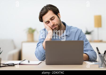 Tired Businessman Sleeping At Laptop Sitting At Desk In Office Stock Photo
