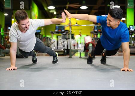 Two young men doing high planks in gym. High quality photo Stock Photo