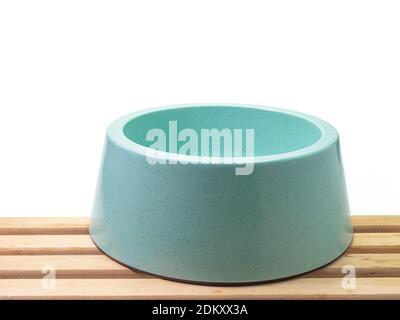 The close up of empty blue green plastic dog bowl, pet equipment isolated on white background. Stock Photo