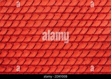 Texture of genuine rough leather close-up, imitation of skin scaly exotic reptile, fashion bright red color, modern background Stock Photo
