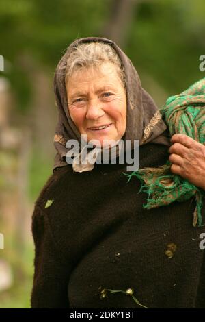 Vrancea County, Romania. Elderly woman returning from the woods with a load of fodder. Stock Photo