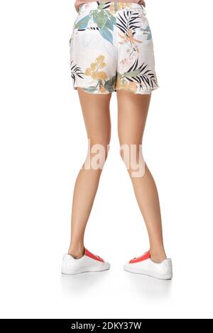 Slim legs of young girl in shorts and sneakers isolated on white background  Stock Photo - Alamy