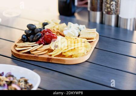 Mix of different snacks and appetizers. Street food plate with set of various kind snacks: bread spicy crackers, french fries and dip, tomatoes, delic Stock Photo