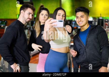 Happy friends with smartphone taking selfie in gym. High quality photo Stock Photo