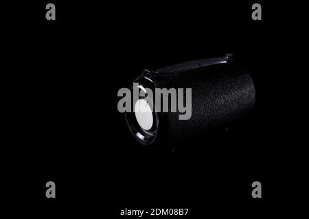 Black wireless portable speaker isolated on black background with copyspace. Stock Photo