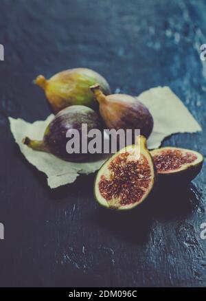 Still life of whole and cut fresh mixed figs fruit on wooden background Stock Photo