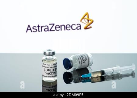 Morgantown, WV - 16 December 2020: Small bottle of coronavirus vaccine with syringe with background of AstraZeneca logo Stock Photo