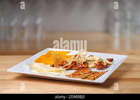 different types of cheese in a restaurant served on a wooden round tray. Copy space. Menu for beer in restaurant Stock Photo