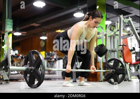 Side view of Athletic woman exercising deadlift in a gym. High quality photo Stock Photo