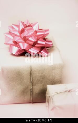 Two gift boxes in romantic pink design, decorated with ribbons and bows. Magic pink background Background for card, flyer, invitation, poster, voucher Stock Photo