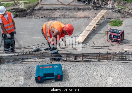 workers in orange vests repair the concrete stairs Stock Photo