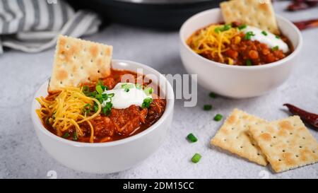 Homemade Turkey bean chili topped with sourcream cheese and green onions, selective focus Stock Photo