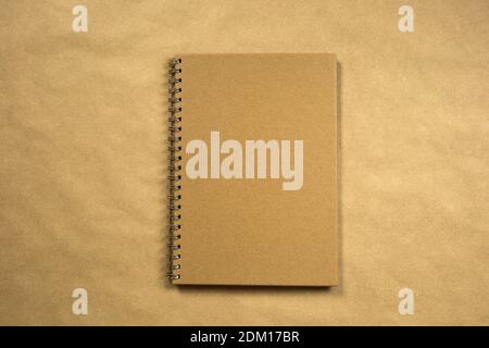 recycled brown paper blank notebook front cover with brown background texture top view, copy space, space for text modern design, business or Stock Photo