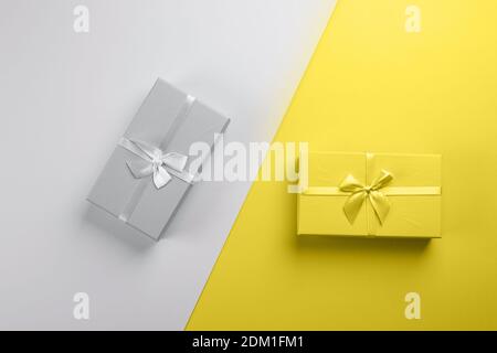 Two gift boxes on gray yellow background. Two-color background. Concept of color year, Stock Photo