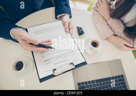 Cropped top above high angle view of his he her she two nice employees coworkers financier economist meeting discussing terms signing paper over table Stock Photo