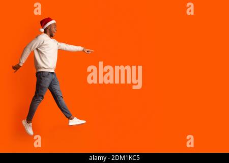 Check This. Excited Black Santa Guy Pointing Aside At Copy Space Stock Photo