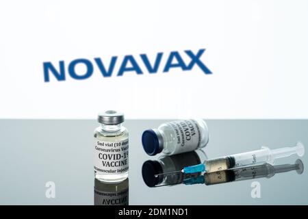 Morgantown, WV - 16 December 2020: Small bottle of coronavirus vaccine with syringe with background of Novavax logo Stock Photo