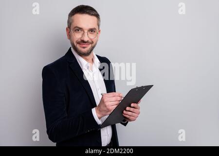 Close-up profile side view portrait of his he nice attractive focused mature man holding in hands clipboard writing recommending memo review isolated Stock Photo