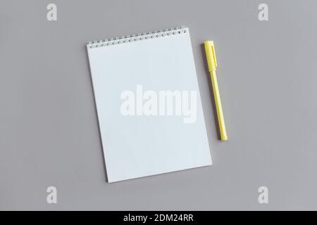Notebook with blank page and pen on a grey background. Flat lay. Place for text. Stock Photo