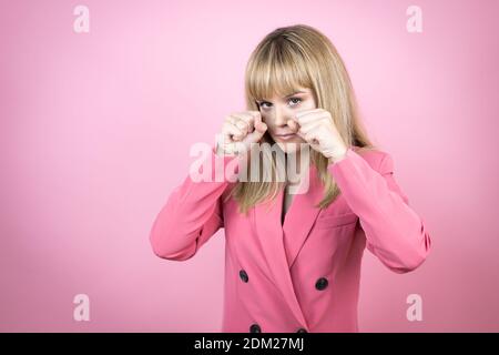 Young caucasian woman over isolated pink background depressed and worry for distress, crying angry and afraid. Sad expression. Stock Photo