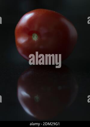 One Roma tomato with black background Stock Photo