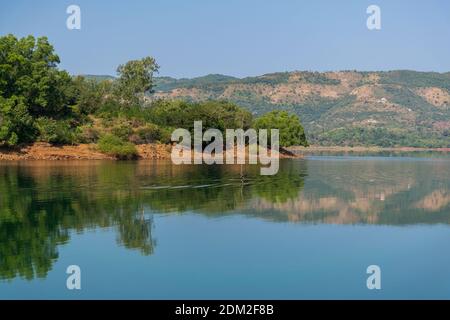 Panoramic view of beautiful Panshet dam with lush green trees on the coast on a sunny morning. The dam is located in Pune, Maharashtra, India Stock Photo