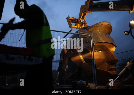 Nethercroy, Scotland, UK, 16th December 2020. Work continues on the installation of a 6-metre sculpture, by artist Svetlana Kondakova, of a Roman soldier's head, nick-named Silvanus - after the Roman God protector of fields, forest and cattle, and a name which chosen by a public vote, at the Nethercroy site on the route of the Roman-era Antonine Wall. The sculpture, built by Big Red Blacksmiths, was commissioned as part of a wider 'Rediscovering the Antonine Wall' project. Working across central Scotland the project aims to build better connections for communities and visitors along the length Stock Photo