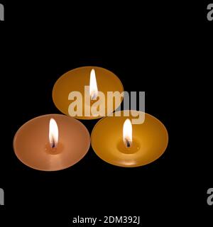 Three tea lights against a black background Stock Photo