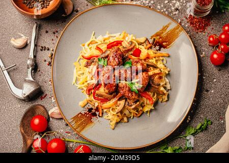 Asian style colorful vegetable and meat stir fry with noodles in spicy sauce.Teriyaki Mongolian beef over udon noodles.Soy sauce beef stew with pepper Stock Photo