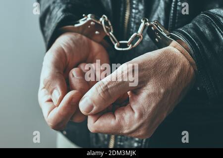 Handcuffed hands, close up with selective focus Stock Photo