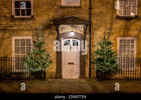 Christmas trees and fairy lights outside a Woodstock house at night. Woodstock, Oxfordshire, England Stock Photo