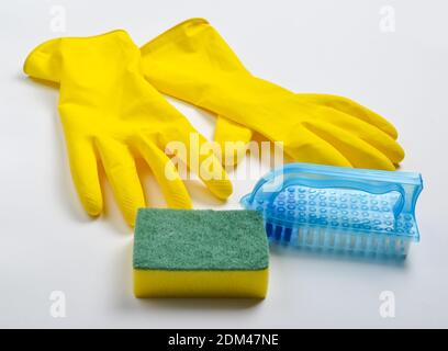 Cleaning equipment on a white background. Yellow latex gloves, brush, sponge. Stock Photo