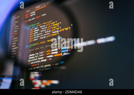 Program code on computer display in magnifying glass. Close-up. High quality photo Stock Photo