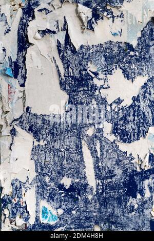 BACKGROUND TEXTURE - Old posters removed from a blue notice board leaving torn remains Stock Photo
