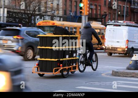 A bicycle courier on a cargo bike in heavy New York traffic. Stock Photo